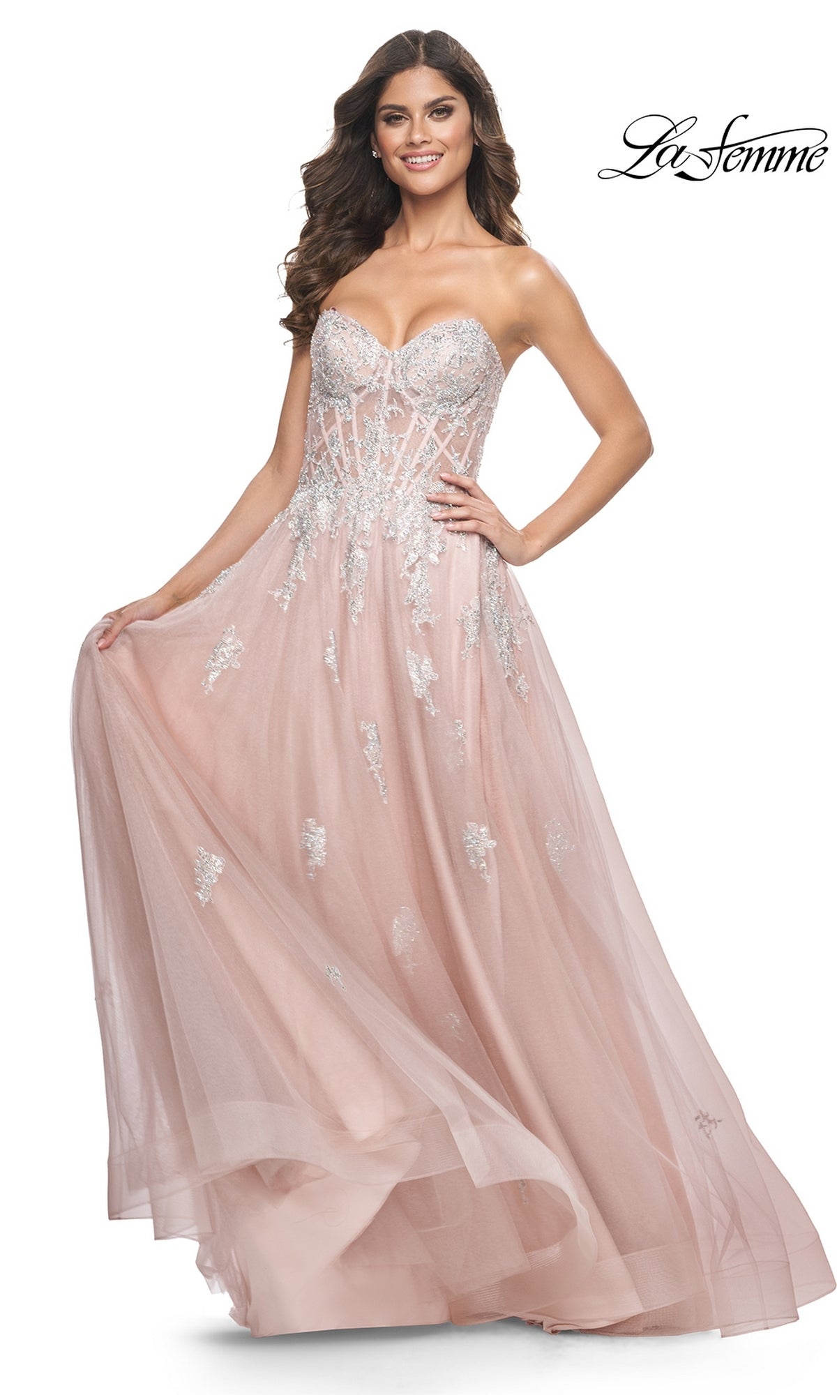 A woman wears the La Femme Strapless Long A-Line Prom Dress 32111 in blush pink, featuring silver embroidered lace appliques, a fitted bodice, and a flowing tulle skirt. The La Femme logo is shown in the top right corner.